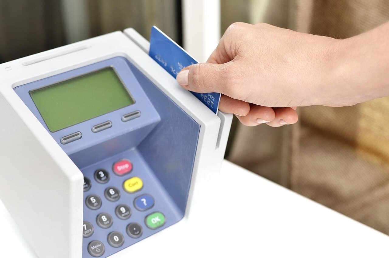 クレジットカードで決済端末に支払いをしている手元のイメージ