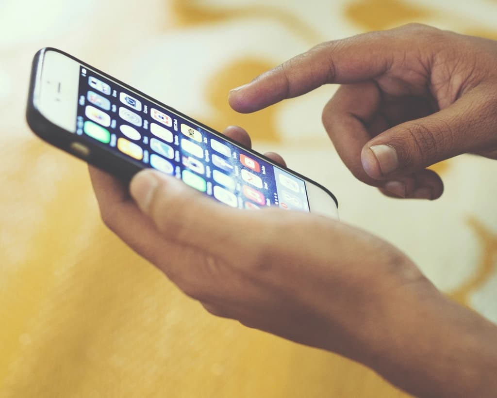 スマートフォンでアプリを操作する手元